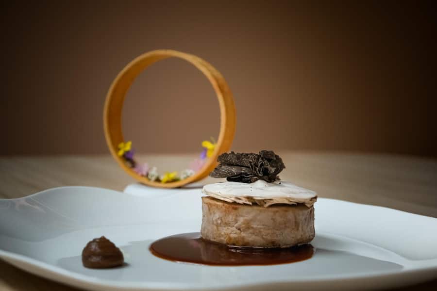 Neu Interpretation Fritschipastete Kalbsfilet mignon, ausgestochen gefüllt mit getrüffeltem Kalbsbrät, ein Wirzblatt und Lammellen aus Champignon mit frischem Perigord-Trüffel. Reduzierter Kalbsjus verfeinert mit Sahne und Rosinengel. Side dish ein Luftbrot mit frischen Käutern und Sprossen.Â