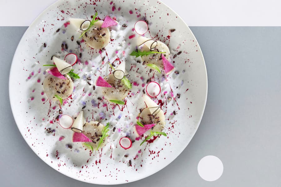 La corolle de coquilles Saint-Jacques de Bretagne marinées aux baies de Litséa, socle de poireau émincé à la crème, légumes racine du marché Pérolles Fribourg Pierrot Ayer