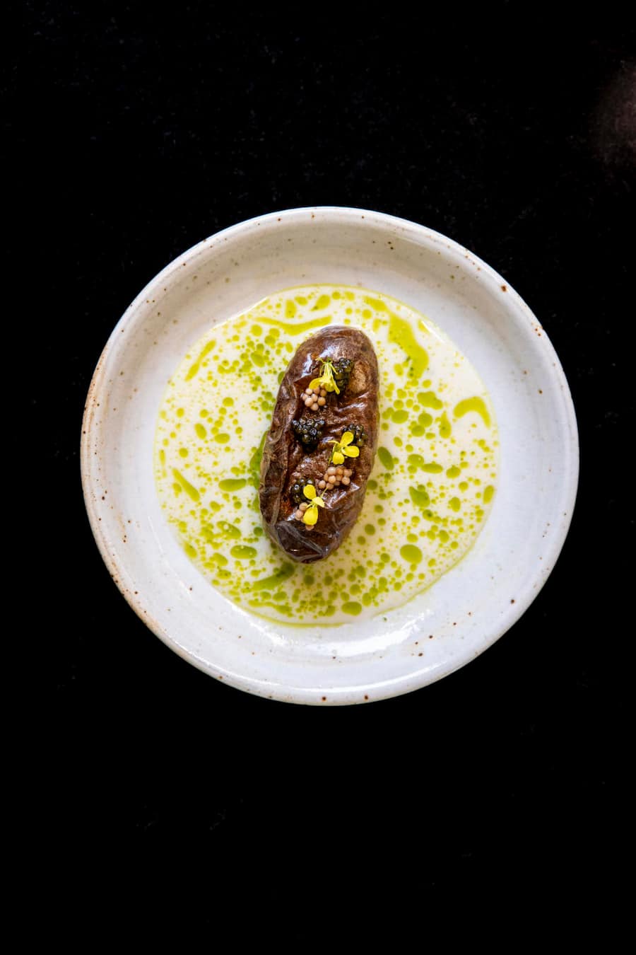 Alpine Kartoffel, Sorte Annabelle Auf Salzkruste gegart, gefüllt mit Semi-Soufflé Osietra-Kaviar Dill-Velouté mit Dillöl . Restaurant CAAA, Pietro Catalano, Luzern. Aufgenommen am 30.04.2024 ©David Birri