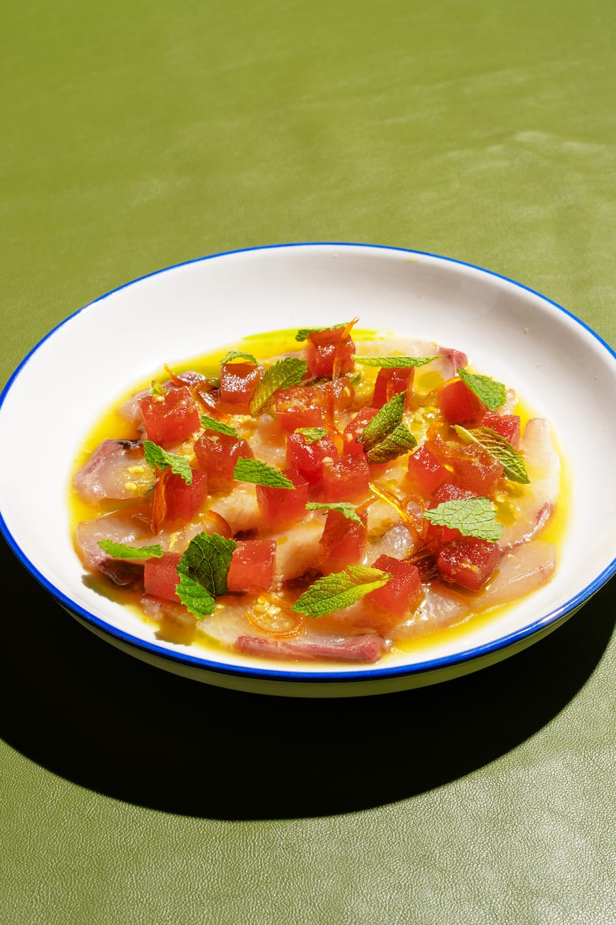 Kingfish mit Nam Jim Seafood Sauce, kandierten Kumquats-Schalen, komprimierte Wassermelone, Minze und Dill-Öl.