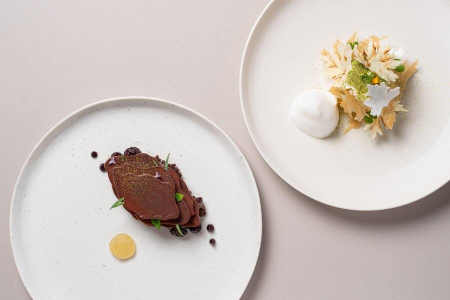 LE MILLEFEUILLE BLANC DE NOS PRÃS crème infusée au mélilot bière vaudoise à la Reine-des-prés - LE CHOCOLAT GRAND CRU DE SAMBIRANO imprégné au carvi, fruits noirs et génépi - Restaurant Anne-Sophie Pic - Hotel Beau-Rivage Palace Lausanne - Sommer 2024 - Copyright Olivia Pulver