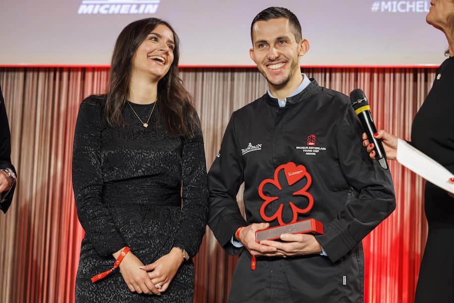 Le chef Gilles Varone de Saviese (droite) recoit le prix du jeune chef 2024 aux cotes de sa femme (gauche) lors de la ceremonie pour l'annonce de la selection des restaurants 2024 par le guide Michelin Suisse, ce lundi 21 octobre 2024 a l'Ecole Hoteliere de Lausanne (EHL) a Lausanne. (KEYSTONE/Valentin Flauraud)
