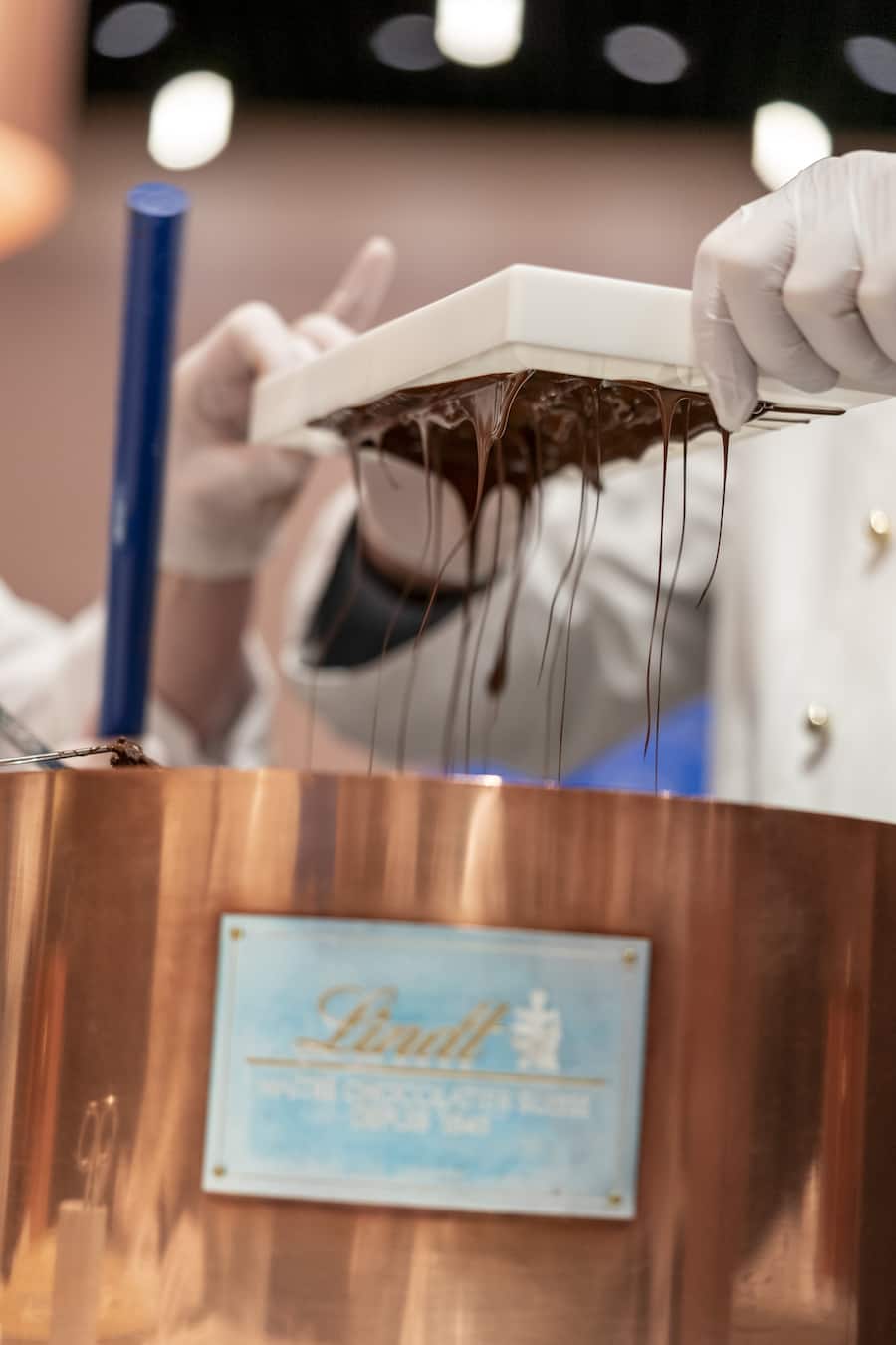 Bevor die Füllung in die Form kommt, wird diese mit Schokolade ausgegossen. Was zu viel ist, kommt wieder in den Topf.