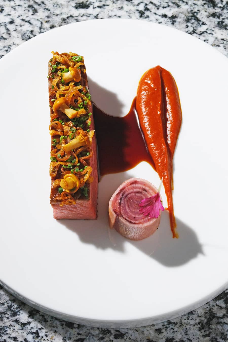 Eringer-Entrecôte knochengereift mit Harissa und Rettich-Chicorée Rolle und Röst-Schalotten