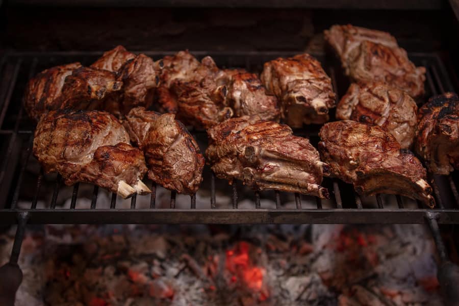 Am Stück grilliertete Kotelettes vom Ostschweizer Kalb über dem Feuer.