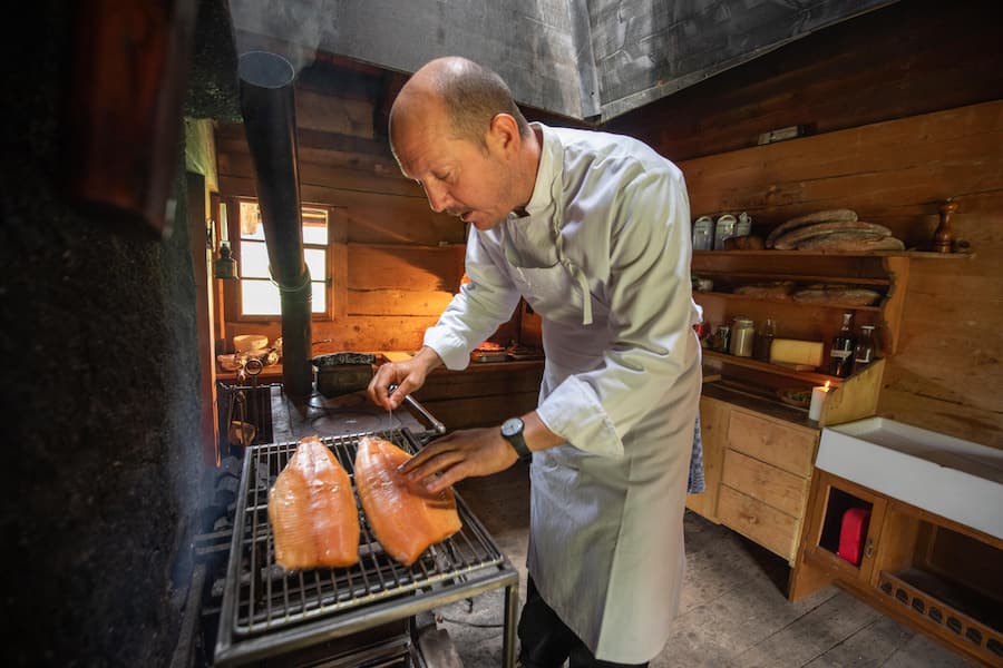 Arbeitsplatz Feuerstelle! Nicolas Darnauguilhem bereitet die Riesenforelle aus dem Lac Léman zu: «Allzu viel Hitze darf nicht sein.»