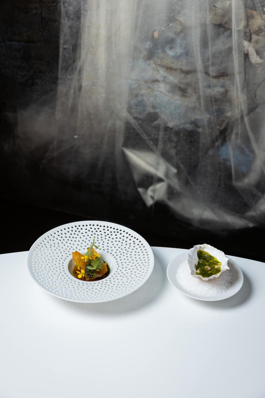 13.06.2025, Vals GR, Restaurant Silver, Papada vom Iberico Schwein, Kohlsauce mit Kimchi-Saft und Liebstöckelöl; Austern mariniert mit Schalotten und Champagneressig(photo by Remy Steiner for Gault Millau)