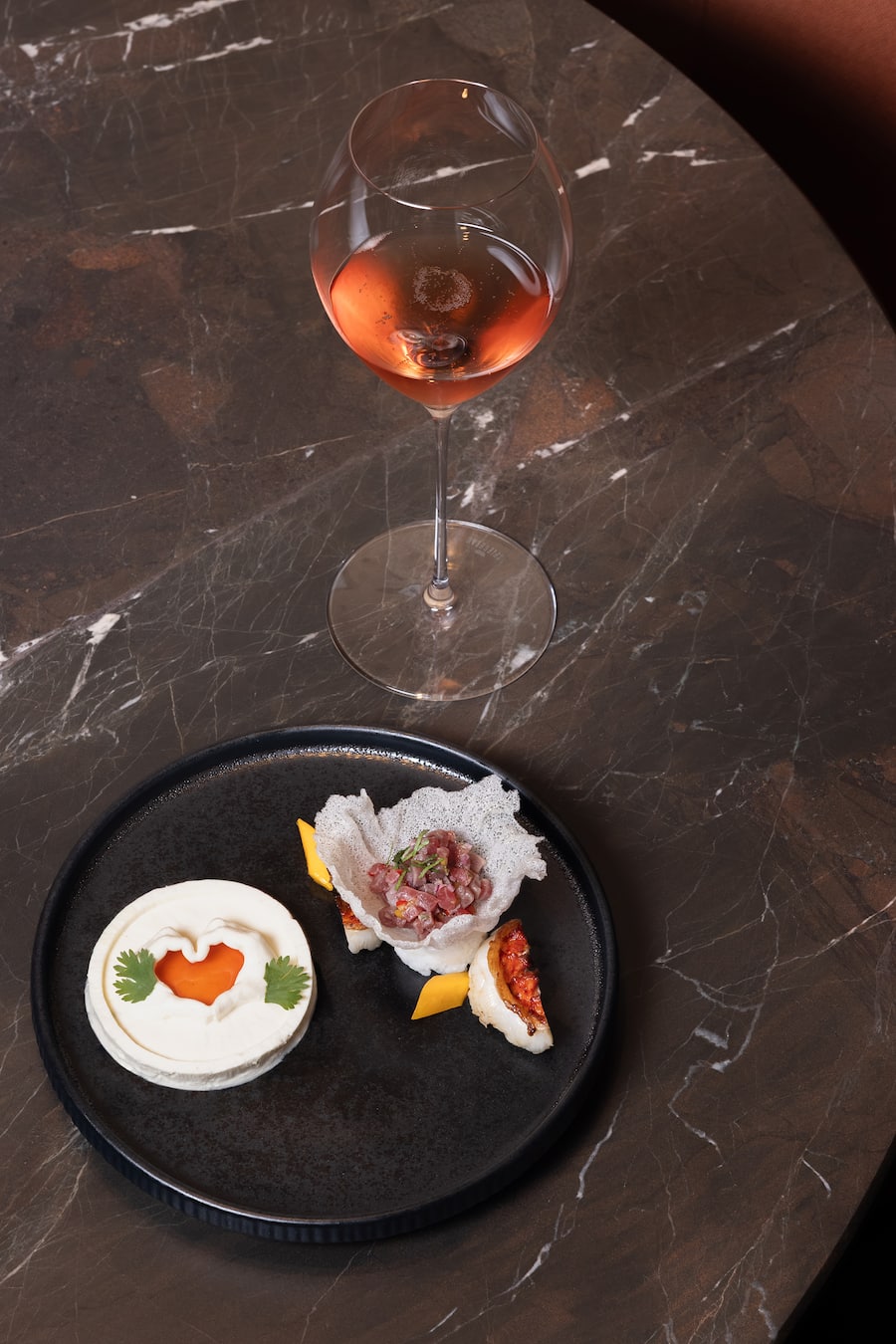 Ein Gericht von Koch Bernd Fabian aus einem Ingwer Zitronengras Mousse mit Chiliöl, Rundkornreis, Hummer und Balfego Thunfisch, Champagner Laurent-Perrier Cuvée Rosé dazu, 13. August 2025, Hotel Chasa Montana Samnaun, Copyright: Simone Lombard