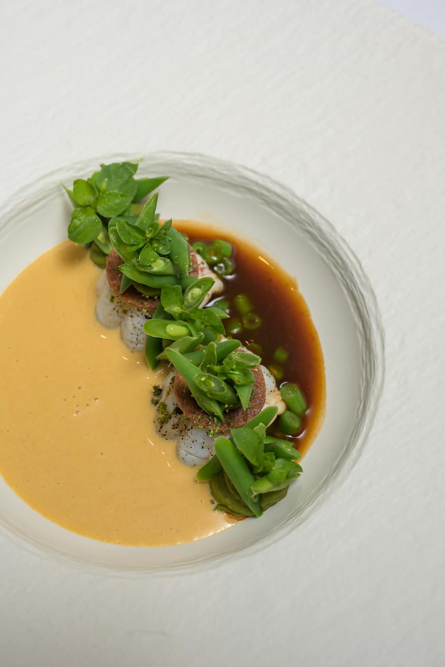 Epatant? Somptueux? Prodigieux? Les adjectifs manquent pour décrire ces langoustines pochées au corail, haricots de Vinzel et sabayon infusé au café.