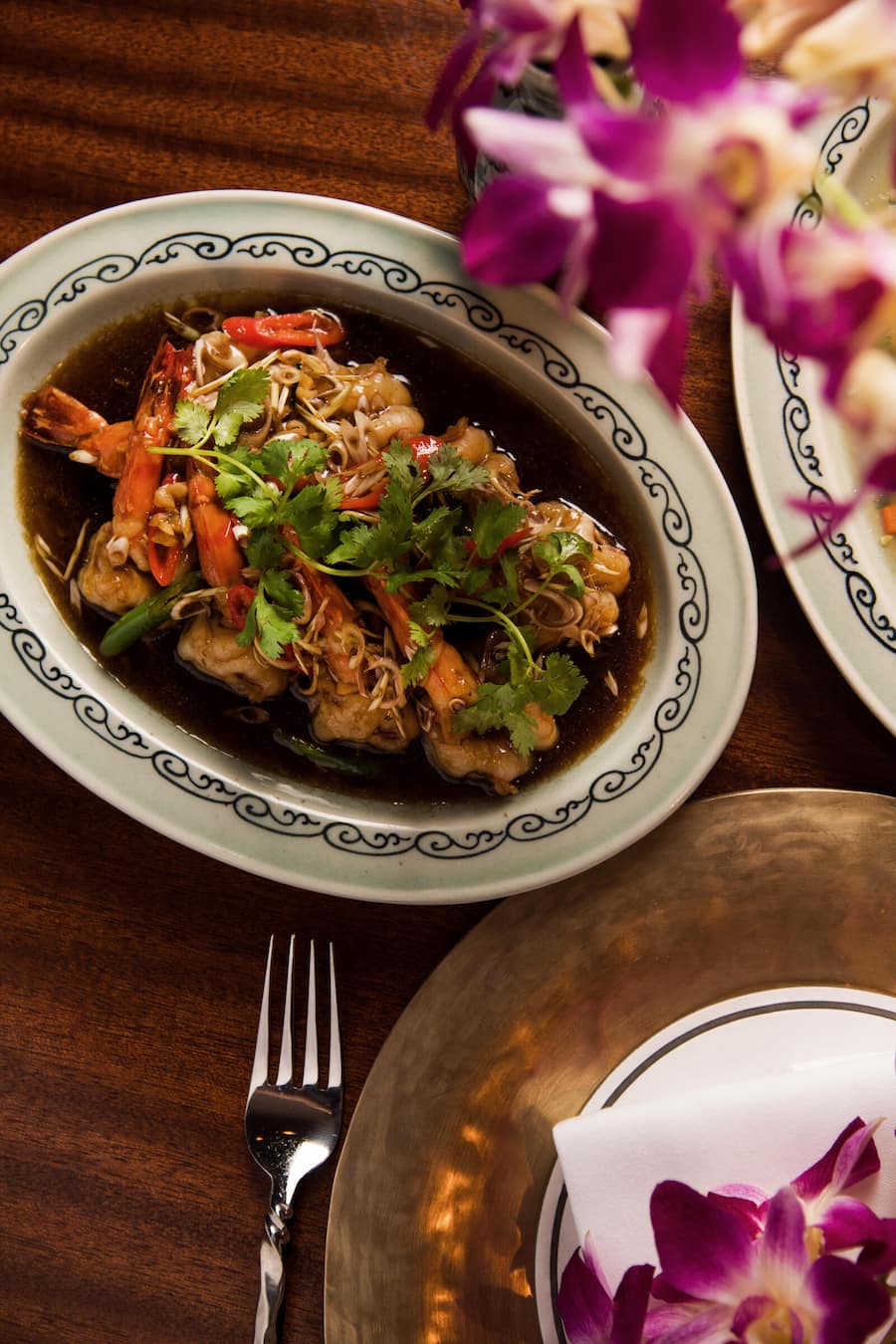 Gung Takrei: im Wok gebratene Riesencrevetten an Austernsauce, gewürzt mit Zitronengras, frischem Chili, Knoblauch und Koriander.