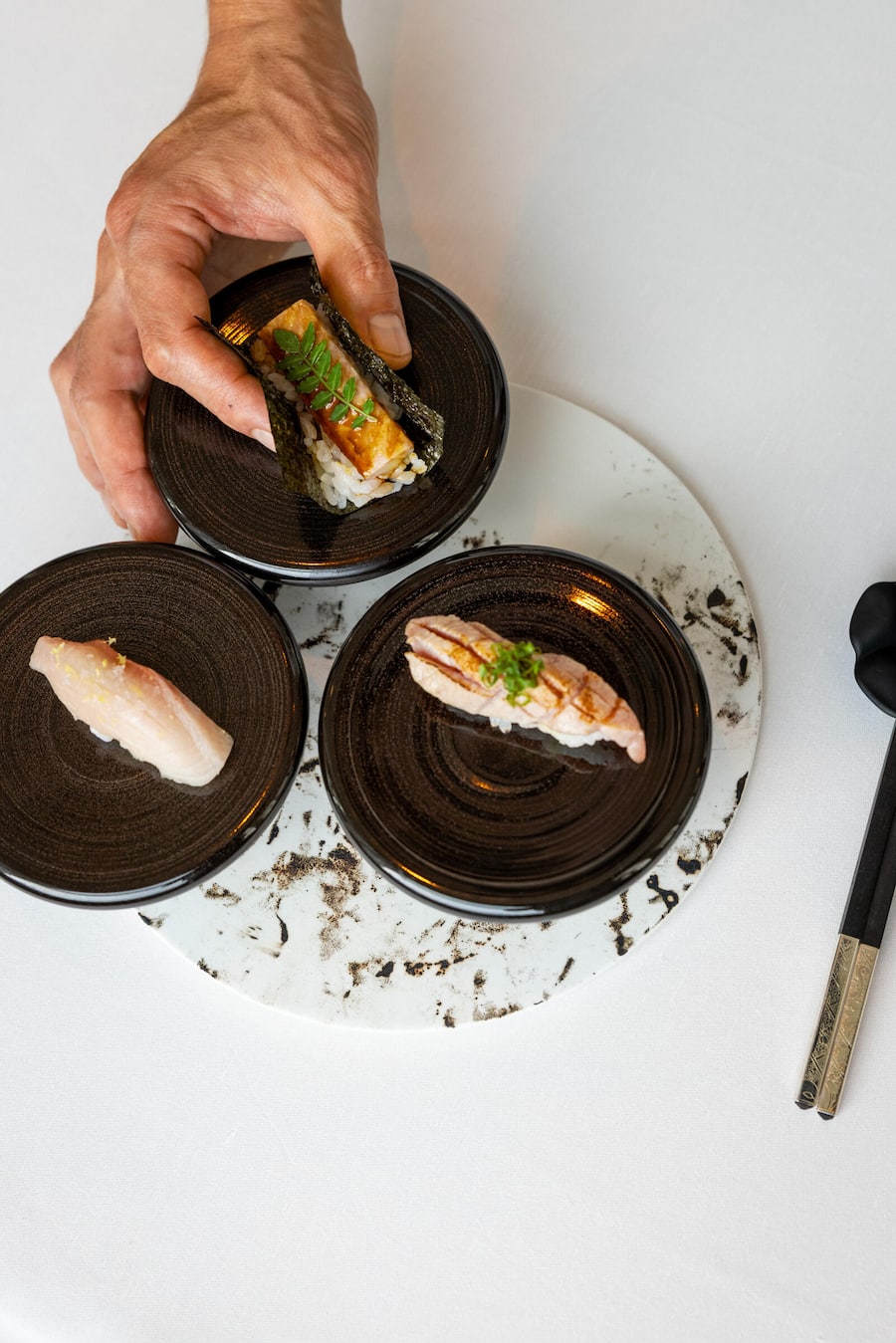 30.09.2025, Luzern, Minamo, Gericht; Oben: Unagi - Smoked Eel, Links: Shiromi - Kingfish, Recht: Kuro Maguro - Spanish Bluefin Tuna (photo by Remy Steiner for Gault Millau)
