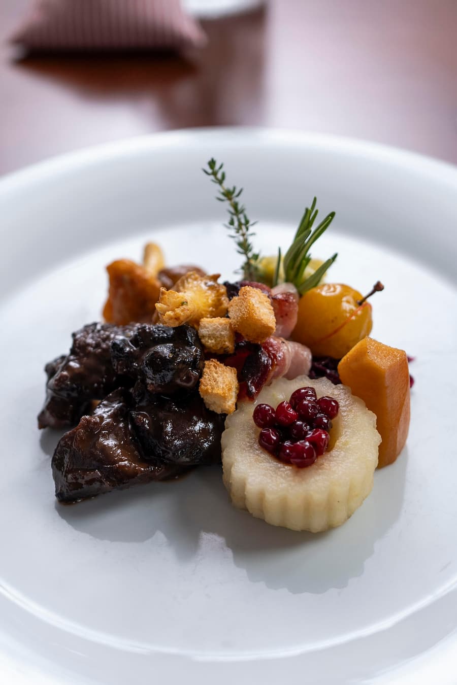 Gemspfeffer mit Wirz, Rotkraut, Mirabelle, Quitte, Vanille-Apfel, Maroni, Brotwürfel und Eierschwämmli. © Valeriano Di Domenico