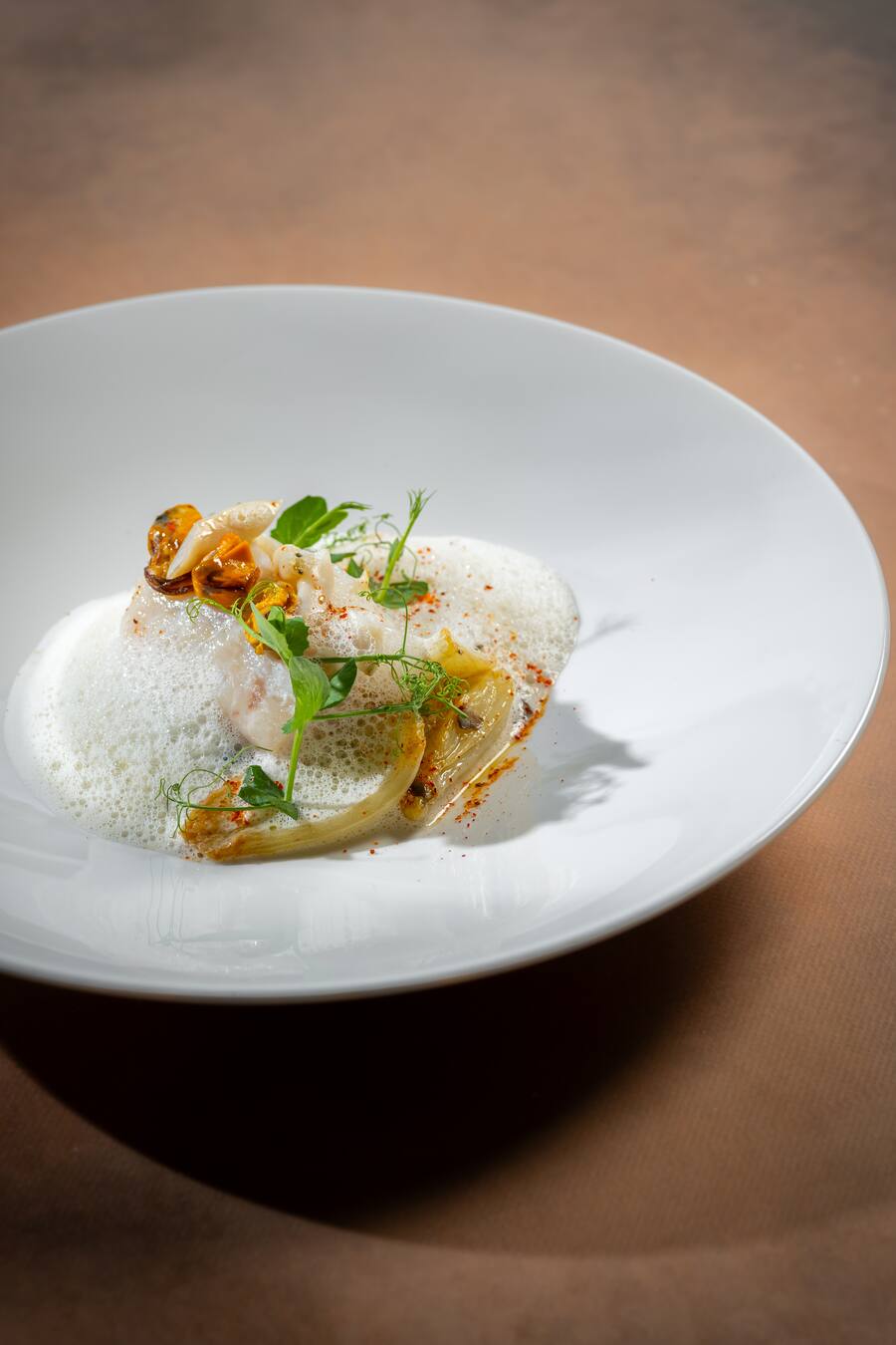 In Mandelmilch pochierter Kabeljau-Rücken mit Clementinenöl.