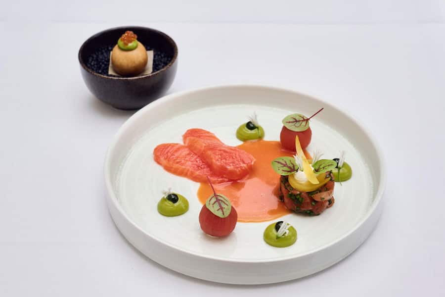 Kundelfinger-Lachsforelle auf drei Arten Sashimi, Tatar, Buñuelo, Bärlauchblume.