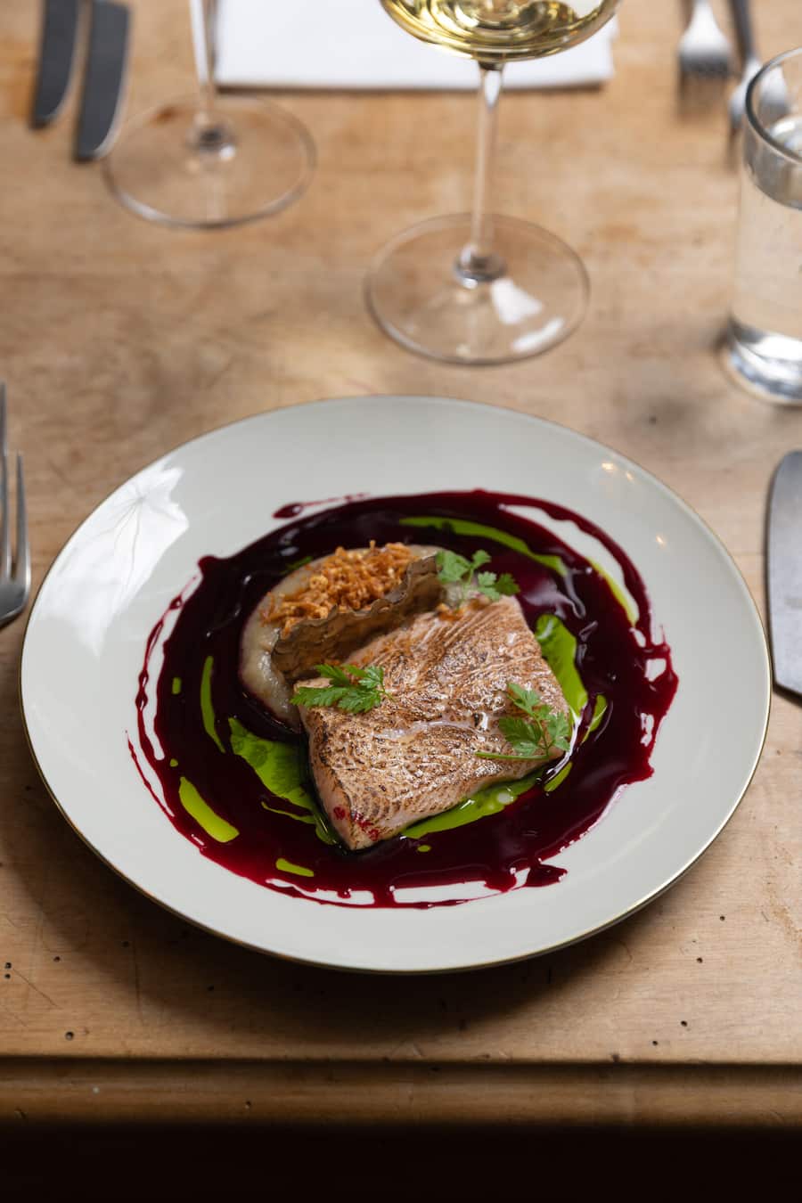 Oerlikon-Report Fotografiert am 19.11.2026 in Oerlikon Restaurant Satt Gericht: GEFLÃMMTE BACHSER LACHSFORELLE,Topinamburpüree,Randenreduktion,Estragonöl,frittierte Schalotten