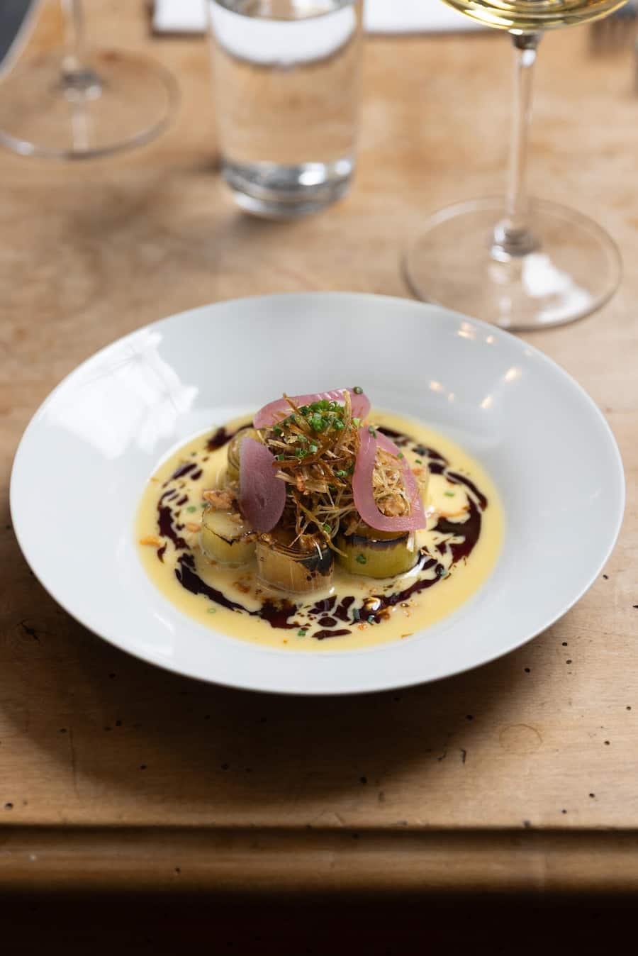 Oerlikon-Report Fotografiert am 19.11.2026 in Oerlikon Restaurant Satt Gericht: GESCHMORTER LAUCH, Rauch-Beurre Blanc, Kürbiskernöl, Baumnüsse, eingelegte rote zwiebeln