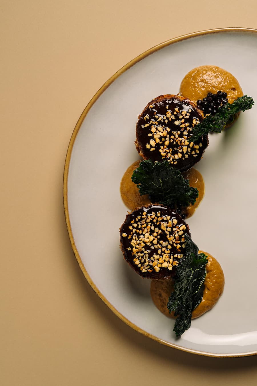 Geschmorter und gezupfter Ochsenschanz, Knödel mit Wollschweinspeck, karamellisierte Zwiebelespuma, gepickelte Holunderbeeren aus dem Garten, Federkohlchips, geröstete Haselnüsse - Hotel Villa Honegg, Ennetbürgen - Küchenchefin Nadine Stadelmann - November 2025 - Copyright Olivia Pulver