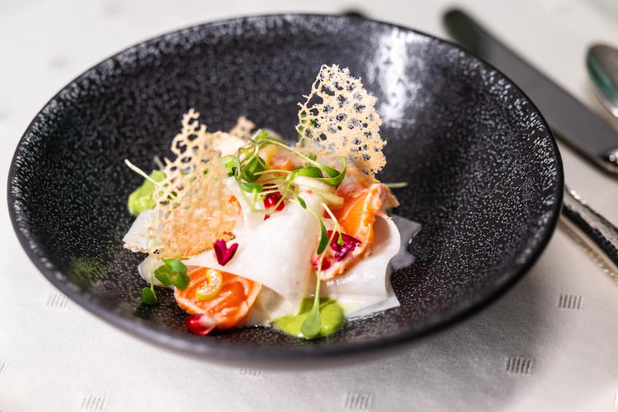 Alpenlachs-Tataki mit Kohlrabi, Frühlingszwiebel und Granatapfelkernen.