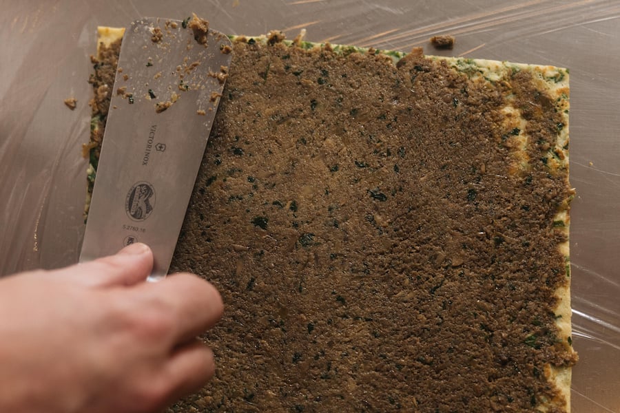Der erste Schritt: Pilz-Duxelles auf der Spinatcrêpe, dünn aufgestrichen.