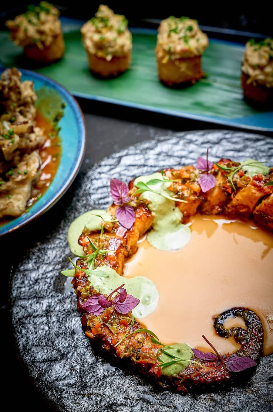 Pulpo mit Chimichurri, Anticucho-Sauce, Bohnencreme und Paste aus rotem Chili.