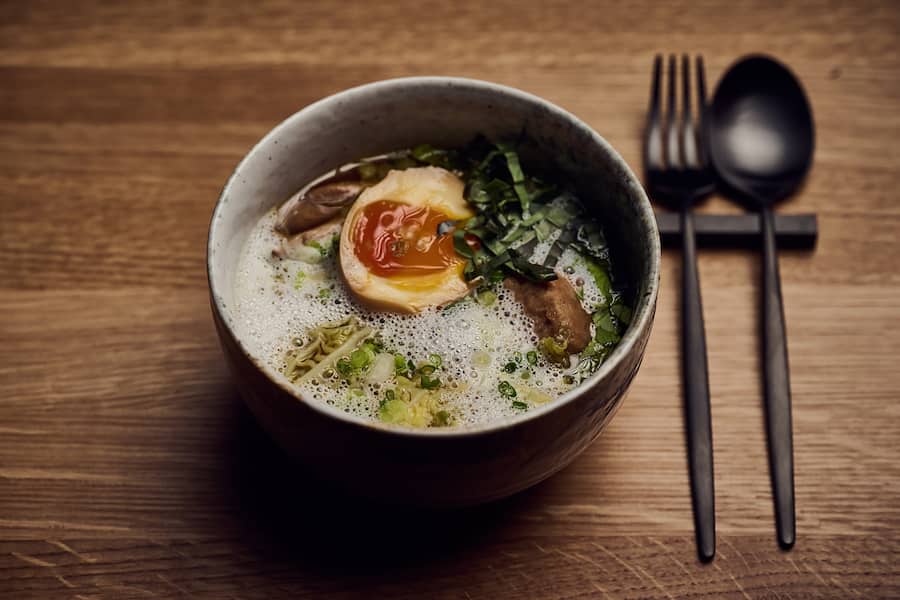 Ramen, Hühnerbrühe, gezupfte Pouletschenkel, Chicken-Meatballs, Thaisellerie, Thaibasilikum, Koriander, Eiernudeln