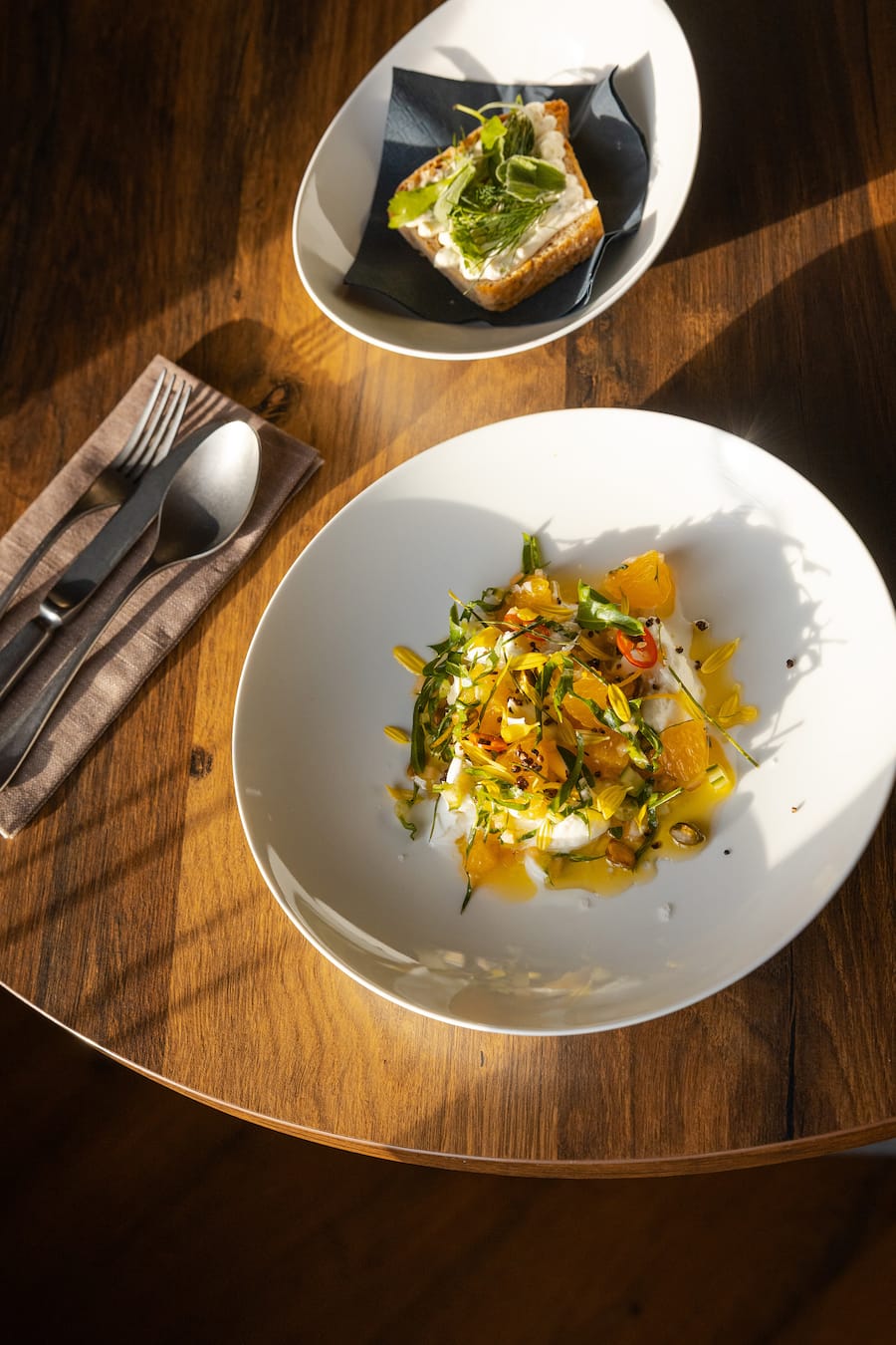 10.12.2025, Hurden SZ, Restaurant PUR, Gericht; Mozzarella, Orangen, Peperoncini, Puntarella, Pistazien, Limettenblätter aus dem eigenen Garten, Olivenöl Dinkelbrötchen mit Frischkäse und Kräuter (photo by Remy Steiner for Gault Millau)