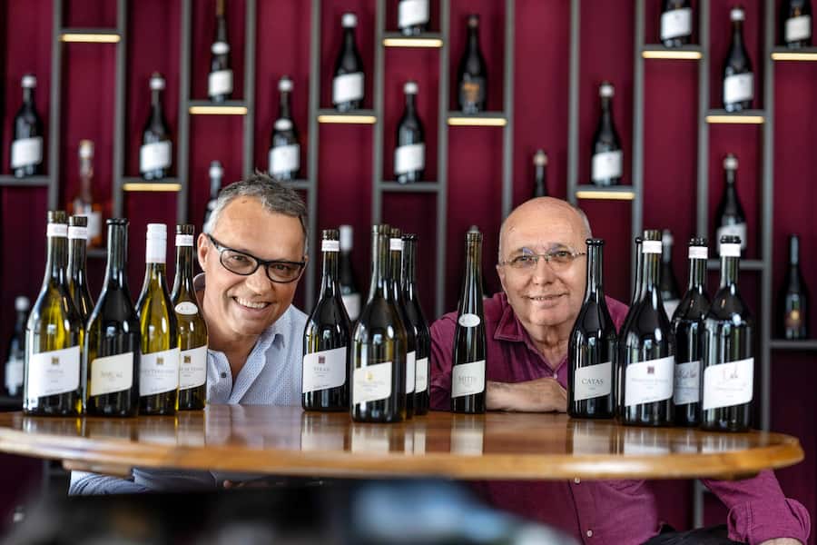 Gilles Besses und Jean-René Germanier posieren zwischen der ganzen Palette ihrrer Weine die bei Coop erhältlich sind