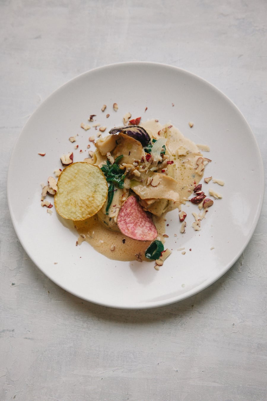 12.01.2025, Zürich-Altstetten, dieCuisine, Gericht; Pilzgeschnetzeltes mit Ackerbohnen-Püree, Bergschnittlauch-Ãl, Bergkartoffelchips & Züri-Ingwer (Hans-Jörg Ladurner) (photo by Remy Steiner for Gault Millau)