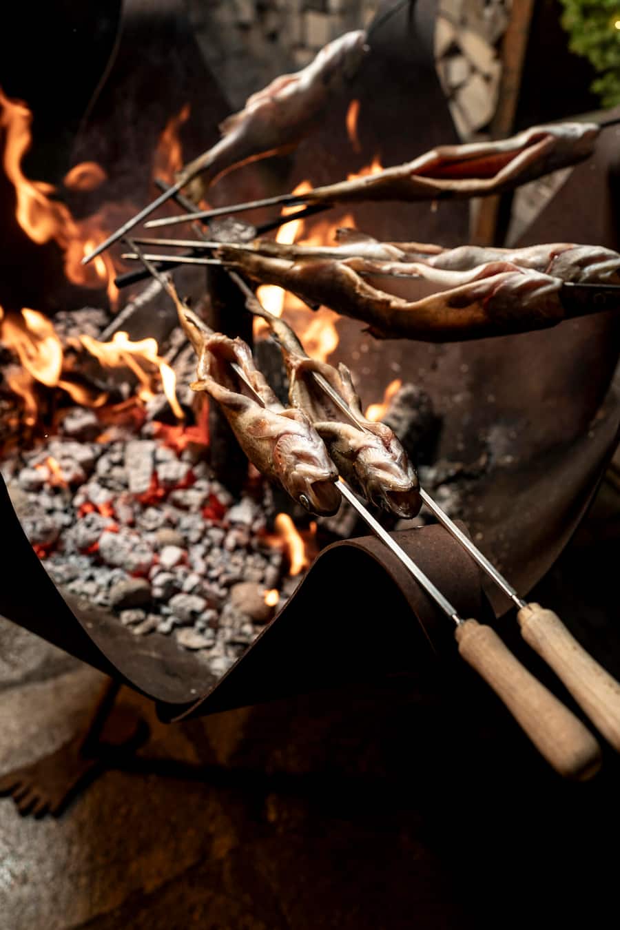 Thomas Graef macht Steckerlfisch auf dem Grill vor dem Haus, Bergrestaurant Höhwald, Monbiel