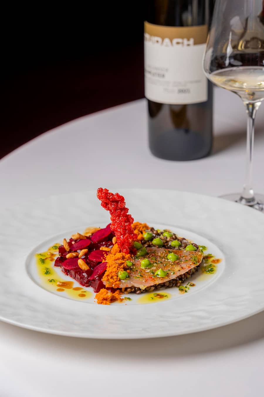 Vorspeise Carabinero-Carpaccio, Beluga-Linsen und Randensalat mit Basilikumcreme und Tapioka-Chips. Wein Completer von Thomas Studach. Fotografiert im Restaurant Schluessel Mels am 28. Januar 2026 fuer die GaultMillau Serie Winzer X Starchef. Bild Yanik Buerkli