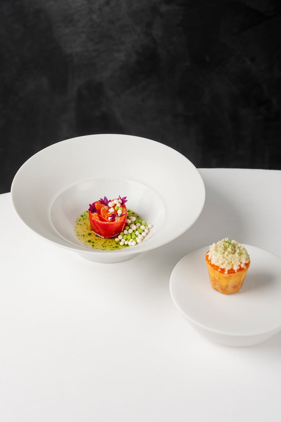 Four-Hands-Dinner mit Marcel Koolen und Rolf Fliegauf im Restaurant 7132 Silver in Vals. Gericht von Rolf Fliegauf: Brueggli-Lachsforelle und Rettich-Rose, dazu Croustarde mit Lachsforellen-Tatar, Meerrettich, aufgeschlagene Creme Fraiche. Fotografiert am 20. Maerz 2026 fuer GaultMillau. Bild Yanik Buerkli