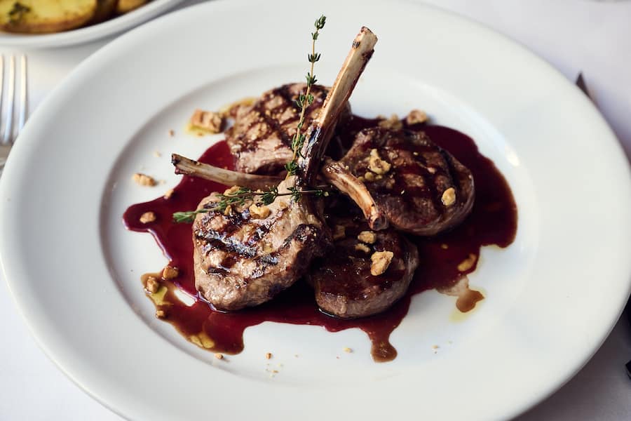 Lammkoteletts mit Dolce Sinfonia-Süssweinsauce, Baumnüssen und Bratkartoffein