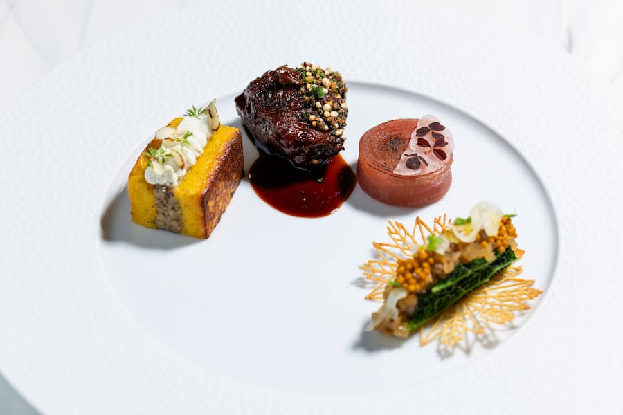 Siegerhauptgang: Geschmorter Lammschulterdeckel mit Thymianjus, Lammhuft-Wirsing-Taco, Gstaader Maisgriessschnitte mit Haselnusskern und Schafskäse, Randen-Millefeuille mit eingemachten Zwetschgen