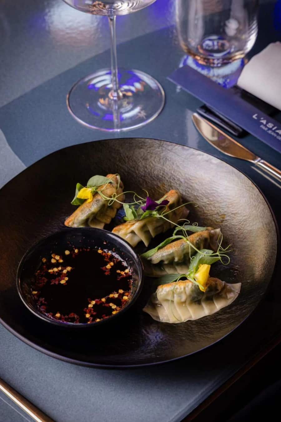Wagyu-Rindfleisch-Gyoza, Rindfleisch-Consommé, Sesam, Chiliöl und Knoblauch.