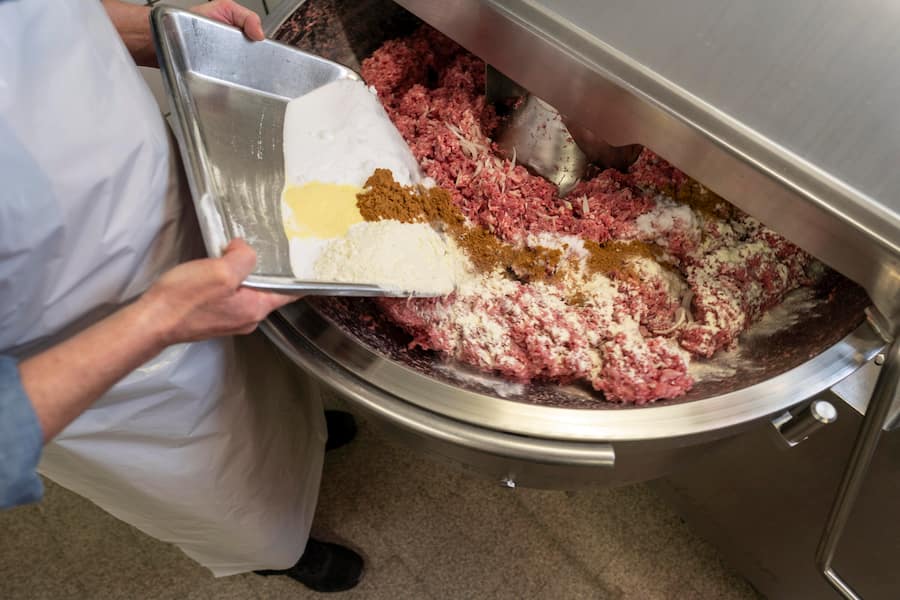 Bechinger Bratwuerste, St. Gallen-St Georgen, Jörg Becher würzt das Kalb- und Schweinefleisch im Blitz