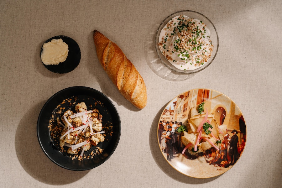 Blumenkohlsalat, Sauerrahmforelle, Knollensellerie-Pastramie, Sauerteig-Baguette und Popcorn-Butter.