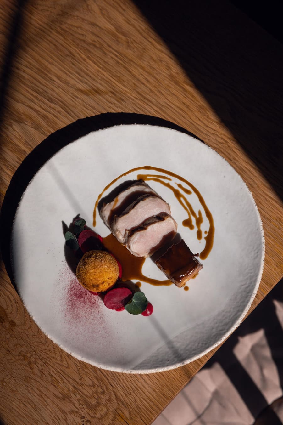17.03.2026, Fribourg, Restaurant Au Chasseur, Gericht; Porc d'ici mit Zwetschge und Rande (photo by Remy Steiner for Gault Millau)