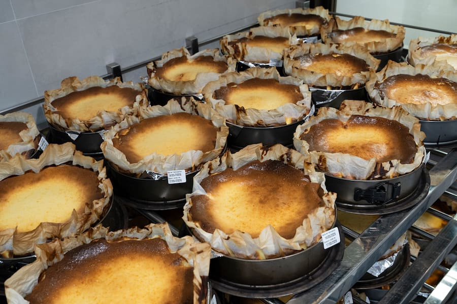 Basque cheesecakes cooling on racks at La Viña's bakery in San Sebastián, Spain, May 14, 2026. Santiago Rivera, owner of La Viña, is widely credited with creating the "burnt" Basque cheesecake in the 1980s, though he doesn't love the spinoffs it has spawned. Decades later, he's preparing to hand over his kitchen to his children. (Markel Redondo/The New York Times)