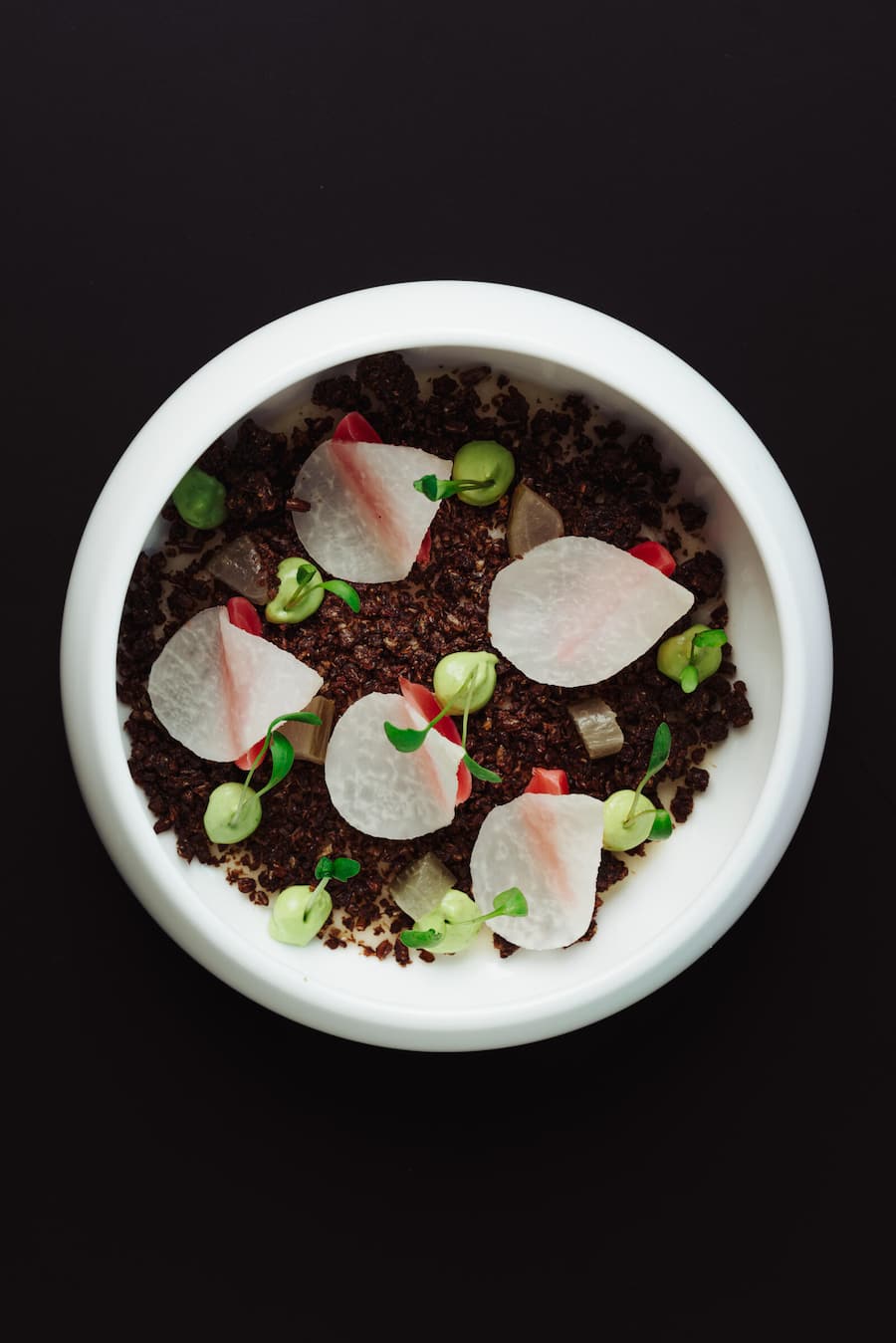 Kohlrabi-Pannacotta mit Pumpernickel, Gartenkressecreme und gepickeltem Gemüse.