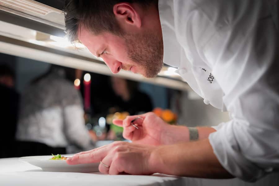 Gourmetfestival St. Moritz 2026. Behind the Scenes, 4 Hands Dinner im Grand Hotel des Bains Kempinski mit Joseph Lidgerwood aus Seoul und Marcel Ravin aus Monaco. Vorspeise von Gastkoch Joseph Lidgerwood (im Bild), Roter Schnapper, Beurre Blanc-Sosse mit Huehnerfett, Gemuese aus der Region. Fotografiert am 27. August 2026