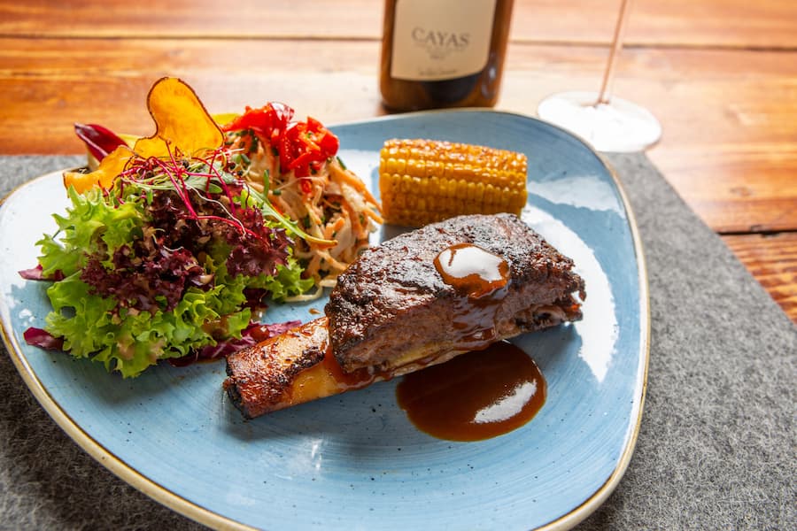 Hauptgang 1: Dry Aged LUMA Wagyu Rinds Short Ribs 24 Stunden langsam gekocht serviert mit Kohlsalat, Blattsalat und Maiskolben