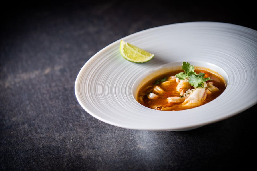 Renu Homsombat, Stefan Heilemann 2022: Tom-Yum-Suppe, Garnelen, Jakobsmuscheln, Tintenfisch, Shimeji-Pilze, Zintronengras, Kaffir-Limette