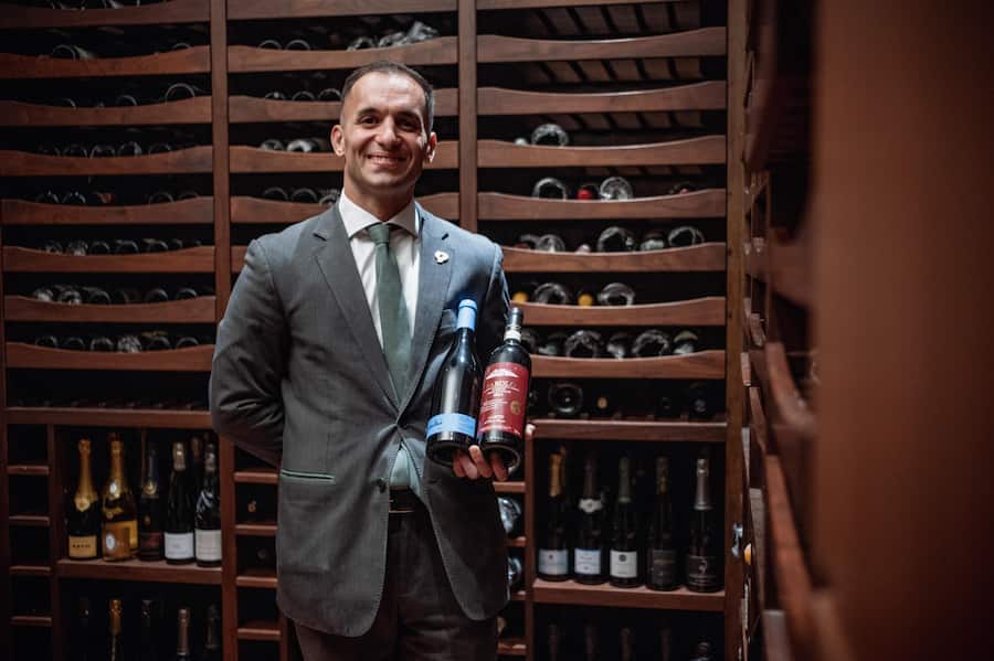 Sommelier Simone Zampini mit Wein von Gantenbein.