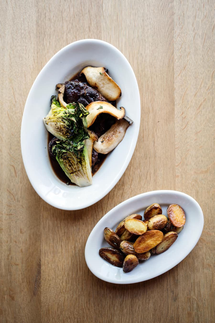 Rinderhaxe mit grilliertem Lattich und Kräuterseitlinge in der Restaurant Metzg von Marlene Halter an der Langstrasse in Zürich Kreis 4