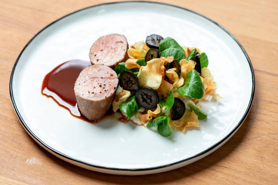 Gebratenes Falsches Filet (Fischli) vom Turopolje-Schwein an karamellisiertem wildem Palmzucker, Petersilienwurzel-Puree, Pastinakenchips, Schwarze Nuesse (vom Hof von Kay, vier Monate in Zuckersirup, Port und Balsamico eingelegt), Nuesslisalat, von Adrian Nessensohn, Restaurant Helvetia, St.Gallen