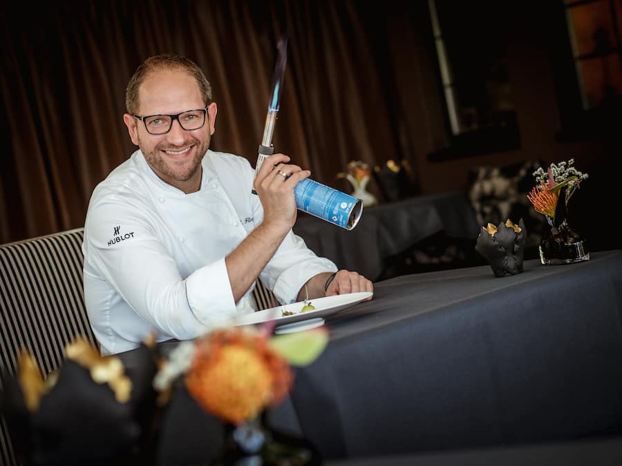 Chefkoch Rolf Fliegauf, Restaurant Ecco, Giardino Ascona - beim Fisch flämmen - 16.8.2018 - Copyright: Olivia Pulver