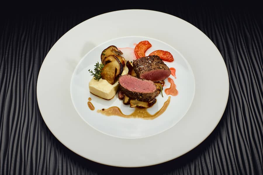 Rehentrecôte im Pfeffermantel mit karamellisierten Quitten, Steinpilze und Selleriepüree