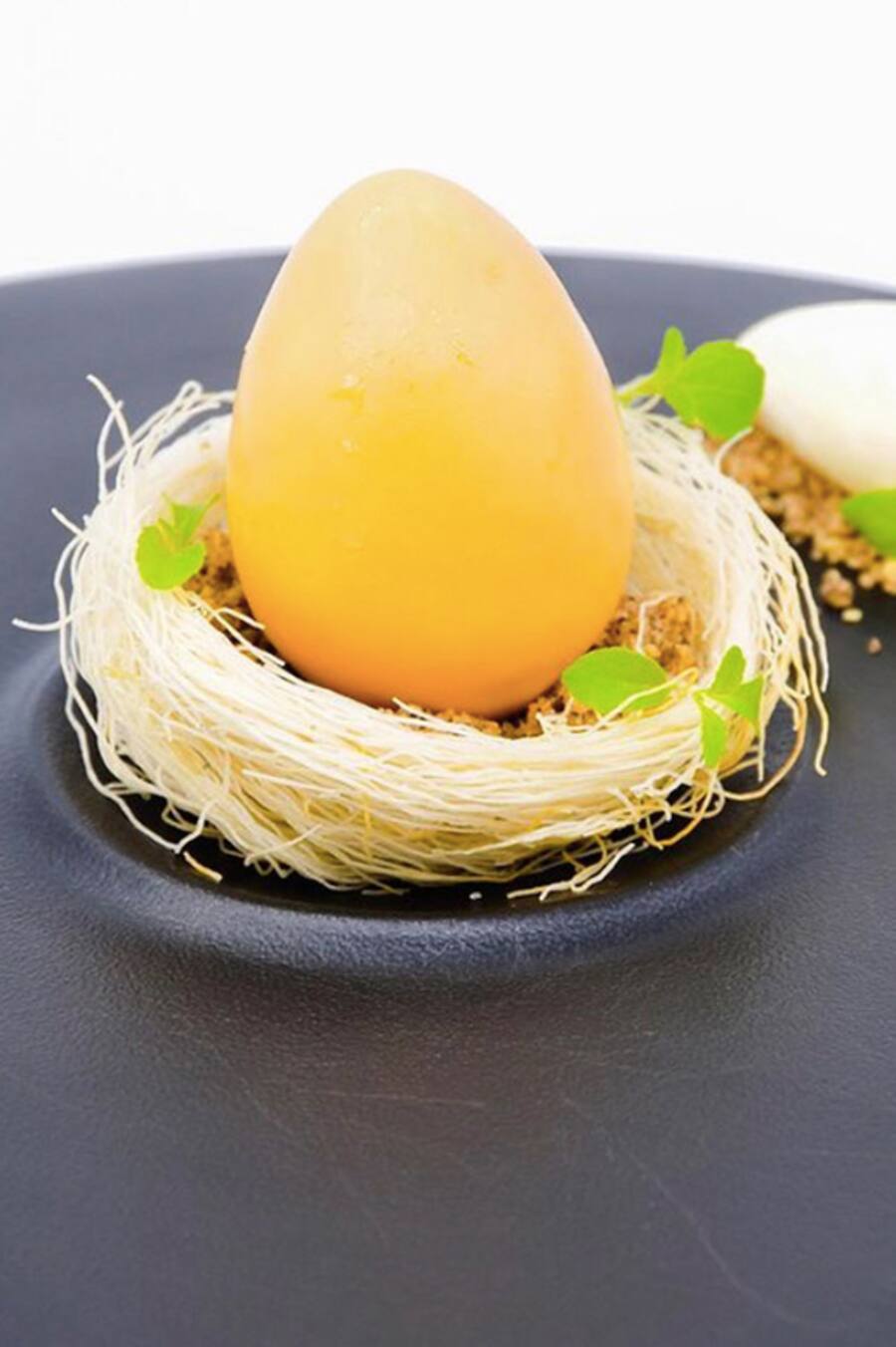 Trompe-l'oeil aus Ei mit Kokosnuss und Passionsfruchtcoulis